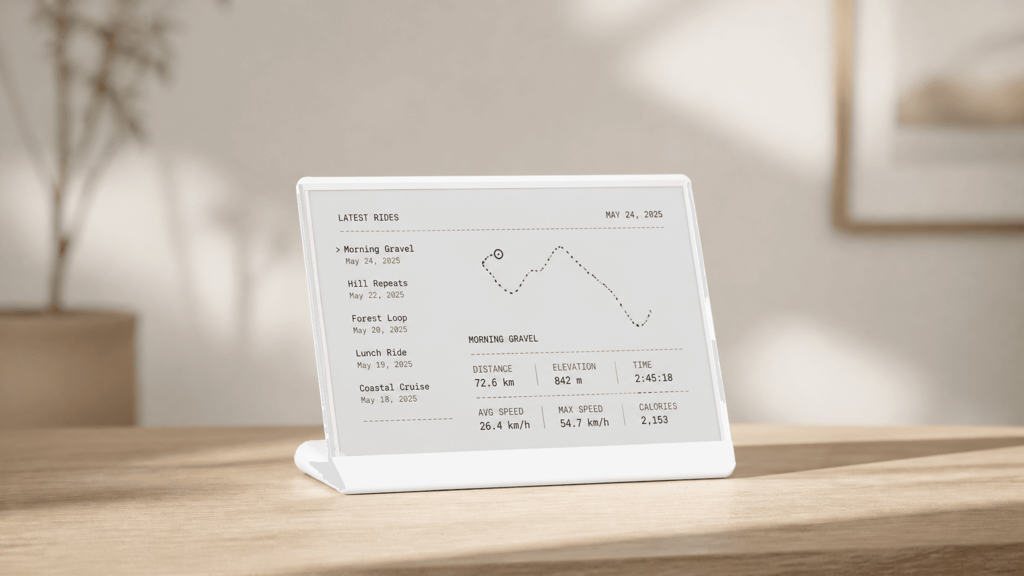 White TRMNL e-ink display on a wooden desk showing Latest Rides